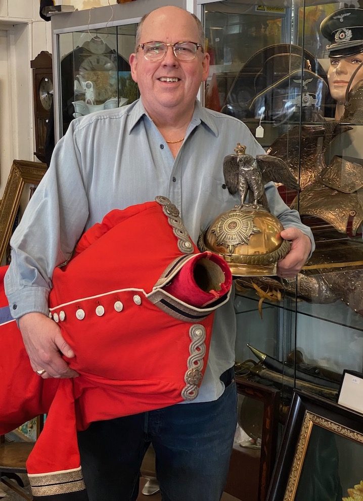 David Mattey holding items of militaria in his High street store .